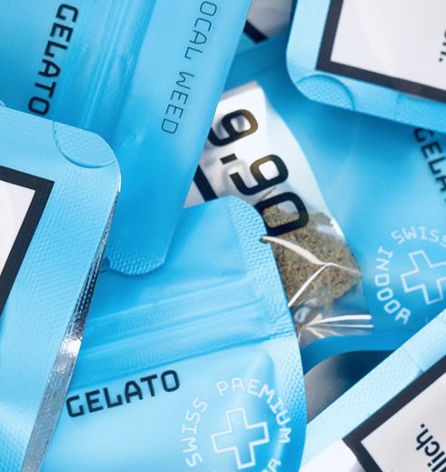 Ein Stapel blauer Verpackungen von Localweed mit der Aufschrift 'Blue Gelato' und 'Swiss Premium Indoor'. Diese Verpackungen enthalten günstige CBD Blüten zum Kaufen.